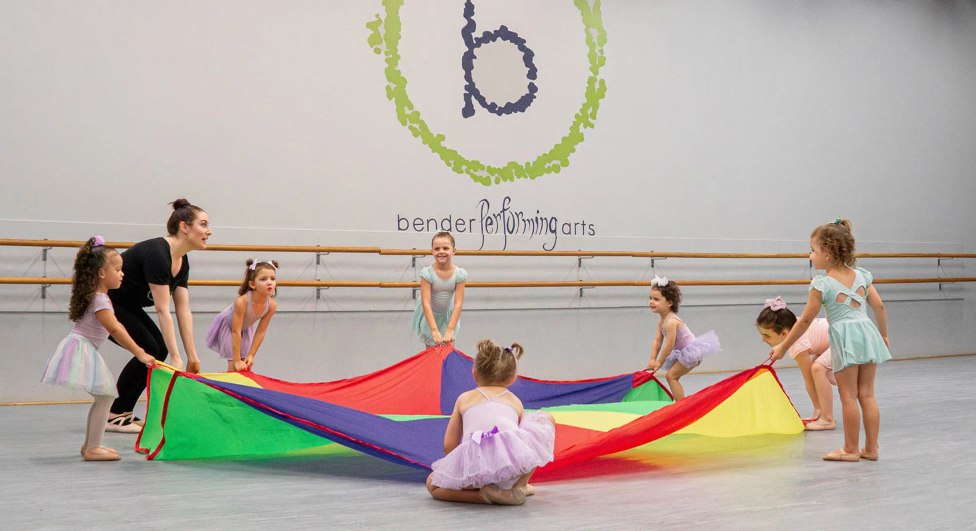 Young dancers and their teacher playing with a parachute at Bender Performing Arts.